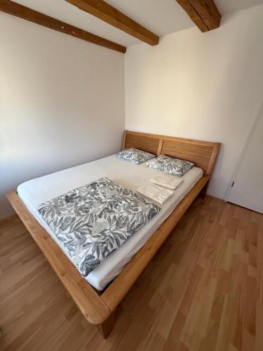 a large bed in a room with a wooden floor at Comfort rooms near Zürich Airport in Embrach
