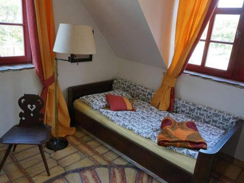 a small bed in a room with windows at Apartment near Leipzig in Taucha