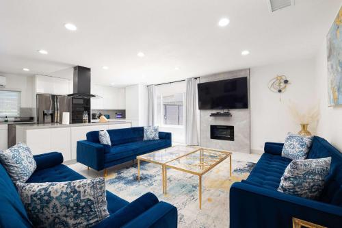 a living room with blue couches and a glass table at Backyard Oasis Private Villa Pool Hot Tub in El Cajon