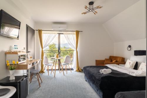a hotel room with a bed and a table and chairs at Siedmiu Króli Rooms&SPA in Bukowina Tatrzańska