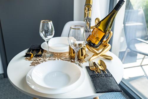 a table with a wine bottle and glasses on it at Siedmiu Króli Rooms&SPA in Bukowina Tatrzańska