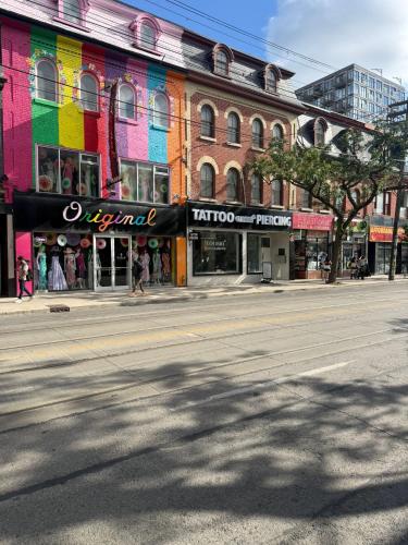 an empty street in a city with shops and buildings at Queen Street AC SUITE-Free Wifi& Self Checkin in Toronto