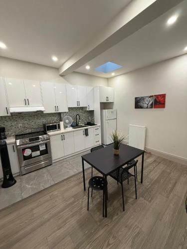 a kitchen with a black table and a kitchen with white cabinets at Queen Street AC SUITE-Free Wifi& Self Checkin in Toronto
