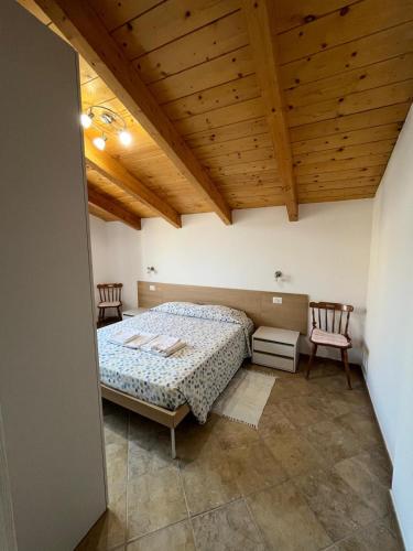 a bedroom with a bed and two chairs at Giulio's House in Alghero