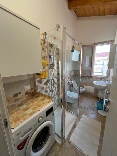a bathroom with a washing machine and a shower at Giulio's House in Alghero