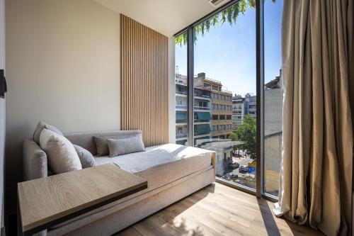a living room with a couch and a large window at Bliss Luxury Apartments in Athens