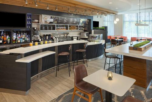 a restaurant with a bar with stools and tables at Courtyard by Marriott Buffalo Downtown/Canalside in Buffalo