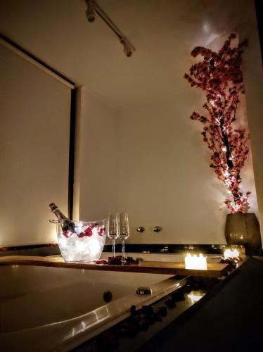 a table with two glasses and a vase of flowers at Cabanas Antonelli in Caxias do Sul