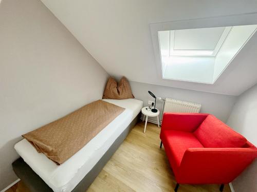 a bedroom with a bed and a red chair at Ferienwohnungen Kapp in Tröpolach