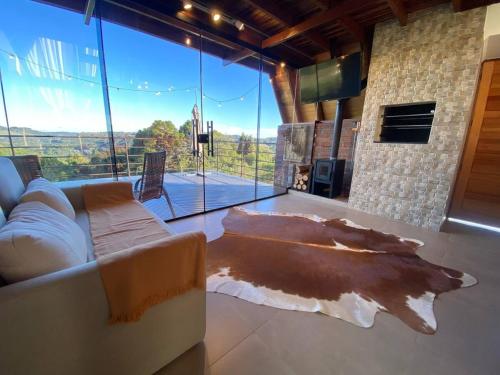 a living room with a couch and a large window at Cabanas Antonelli in Caxias do Sul