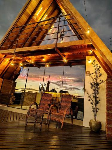 a deck with chairs and a view of a sunset at Cabanas Antonelli in Caxias do Sul