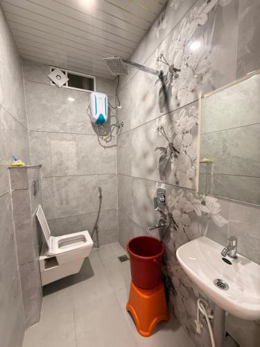 a bathroom with a sink and a toilet and a mirror at Hotel Tathaastu Palace in Ujjain
