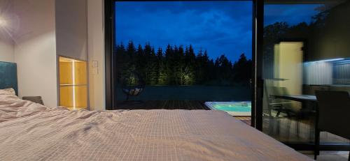 a bedroom with a bed and a large glass window at Paus in Kernu