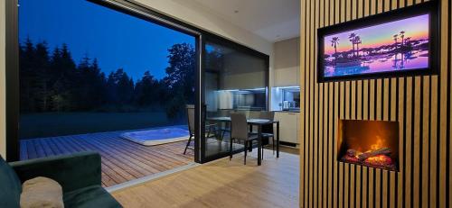 a living room with a fireplace and a view of a kitchen at Paus in Kernu