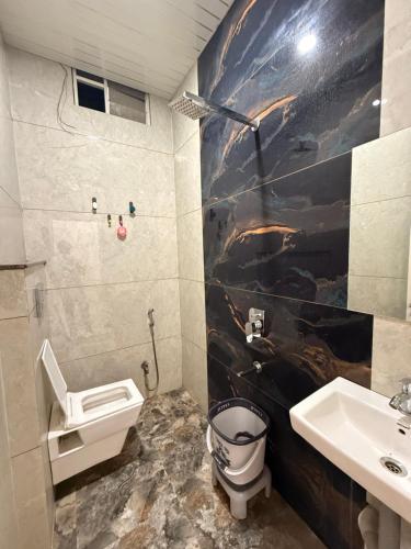 a bathroom with a toilet and a sink at Hotel Tathaastu Palace in Ujjain