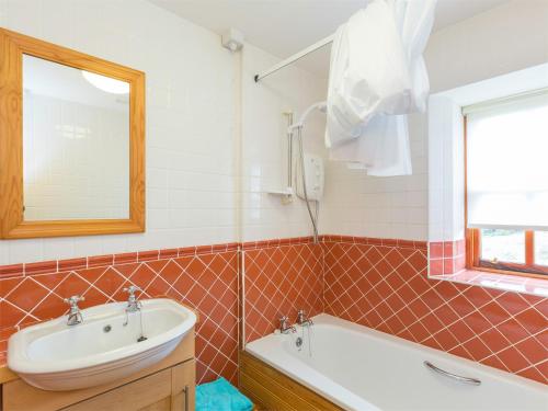 a bathroom with a sink and a tub and a mirror at 2 bed property in Cairnbaan CA113 in Cairnbaan