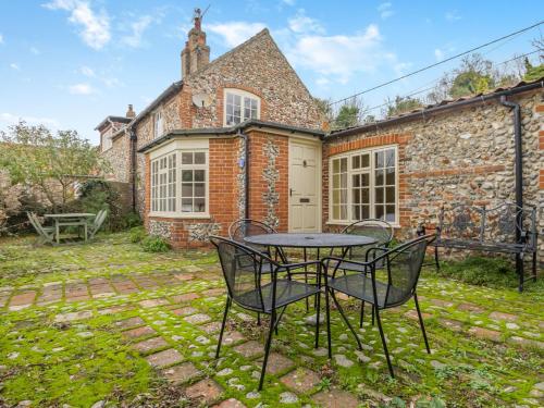 a patio with a table and chairs in front of a building at 3 bed in Stiffkey NCC49 in Stiffkey