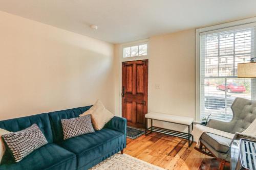 a living room with a green couch and a window at Dtwn at Your Door Historic Frederick Gem with Yard! in Frederick
