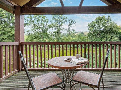 a table with two chairs and a book on a porch at 1 Bed in Garth BN216 in Garth