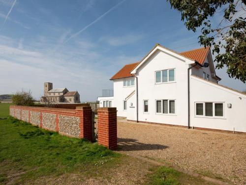a white house with a brick wall at 4 Bed in West Runton 81469 in West Runton