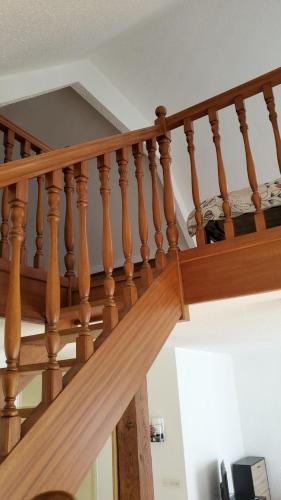 a wooden stair railing in a house at Maison en campagne avec chambre mezzanine in Priziac