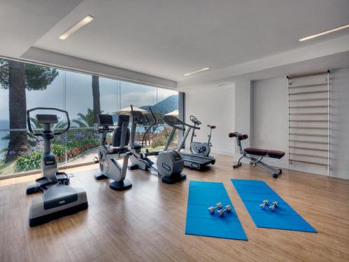 a gym with exercise equipment in front of a large window at Hotel Continental in Santa Margherita Ligure