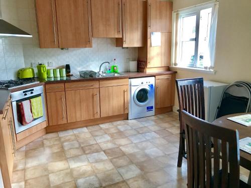 eine Küche mit einer Waschmaschine und einem Geschirrspüler in der Unterkunft Woodgrove Holiday Homes in Inshes
