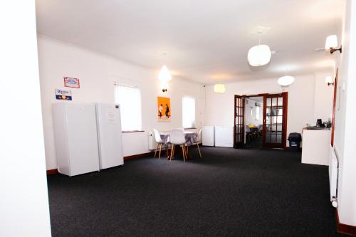 a room with white appliances and a table and chairs at Weston House Keith in Keith