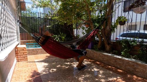 a person laying in a hammock in a yard at Hostal Casa Yare in Rodadero