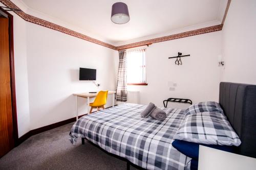 a bedroom with a bed and a desk and a window at Weston House Keith in Keith