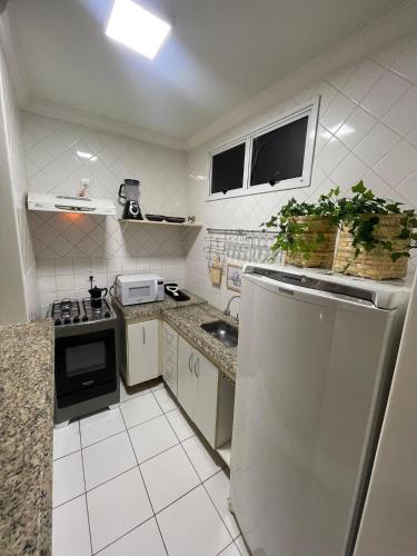 a small kitchen with a sink and a refrigerator at Edifício Belluno in Ribeirão Preto