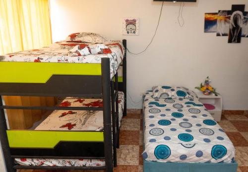 a bedroom with two bunk beds and a small table at Hostal Casa Yare in Rodadero