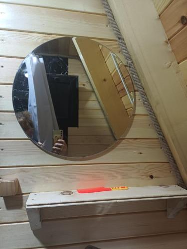 a mirror on a wall with a bench in a room at Mariiko's cottages in Davberi
