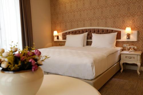 a hotel room with a bed and a table with flowers at Hanzade Park Hotel in Trabzon