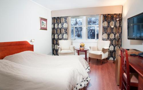 a bedroom with a bed and two chairs and a television at Best Western Tingvold Park Hotel in Steinkjer