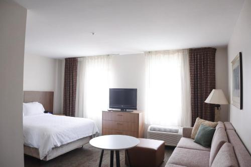 a hotel room with a bed and a couch at Staybridge Suites Austin Airport by IHG in Austin