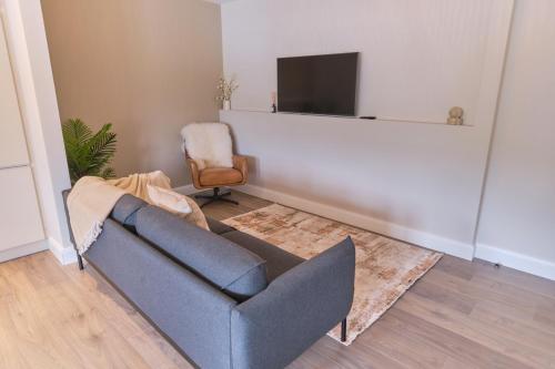 a living room with a couch and a television at Riverside Dingle - Luxury Apt 4 in Dingle
