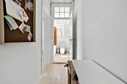 a room with a hallway with white walls and a table at Exclusive apartment in Frederiksber - In the heart of Copenhagen in Copenhagen