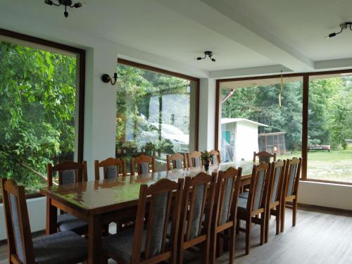 a dining room with a long table and chairs at PENSIUNEA STEFANIA in Brebu Mînăstirei