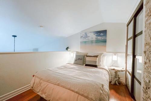 a bedroom with a bed and a painting on the wall at Charming Tremblant 1 Bedroom -Pool Hot Tub in Mont-Tremblant