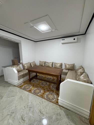 a living room with a couch and a table at MGi2 in Aït Moussa Ou Amar