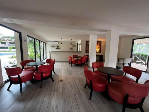 una sala da pranzo con sedie e tavoli rossi di Relaxing Suite Coronado, Panamá a Chame