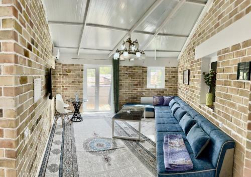a living room with a blue couch and a brick wall at Komolon in Tashkent