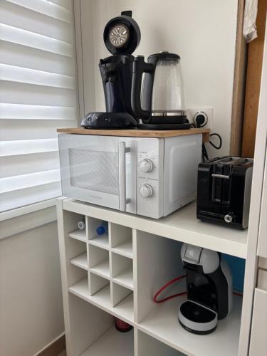 a kitchen shelf with a coffee maker and a blender at Maison 2chambres dressing bureau jardin clos pour 4 Personnes in Saint-Pol-de-Léon