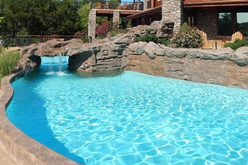 a large swimming pool with a waterfall in a backyard at Stonewater Cove in Shell Knob