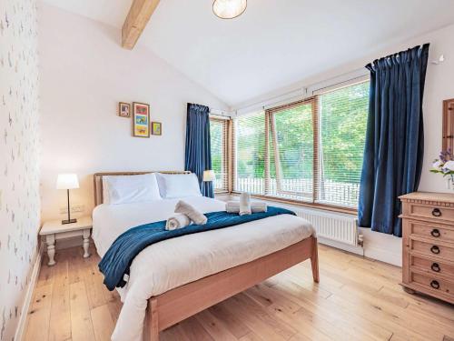 a bedroom with a large bed with blue curtains at 3 Bed in Freshwater East 66265 in Stackpole Elidor