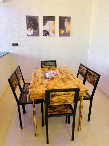 a wooden table with two chairs and a table with at Appartement Calme (1) in Fès