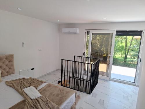 Habitación blanca con cama y ventana grande. en Oaza mira 2, en Jajce