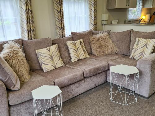 a brown couch with two white tables in a living room at Castle Campbell View in Dollar
