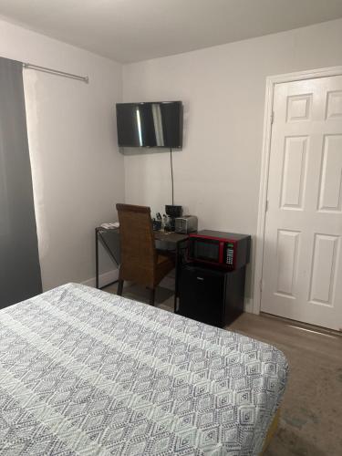 a bedroom with a bed and a desk and a table at Suite in Dania Beach in Dania Beach